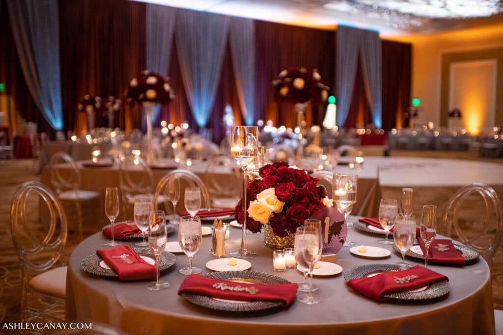 wedding reception decor with red and gold table settings and red and white curtains - margaritaville resort orlando wedding venue